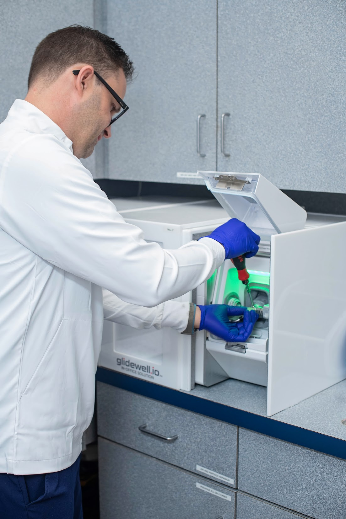 Dr. Prentice retrieving finished crown from Glidewell.io Fastmill after in-office milling process